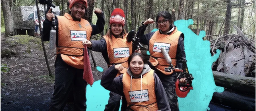 Grupo de amigos con chalecos naranjas de QuitoPaintball celebra tras una partida en la pista de bosque
