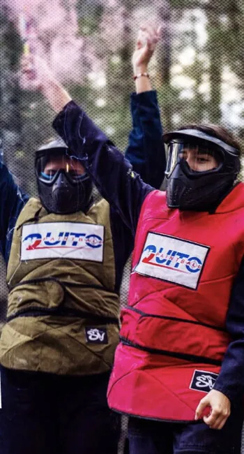 Grupo de una empresa jugando paintball entre cortinas de humo